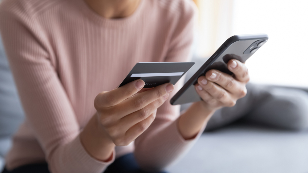 Close,up,female,hands,holding,credit,card,and,smartphone,,young